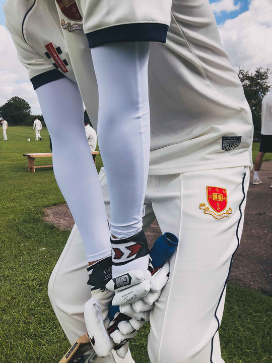 Cricket player with bat wearing Crazy Arms sun sleeves