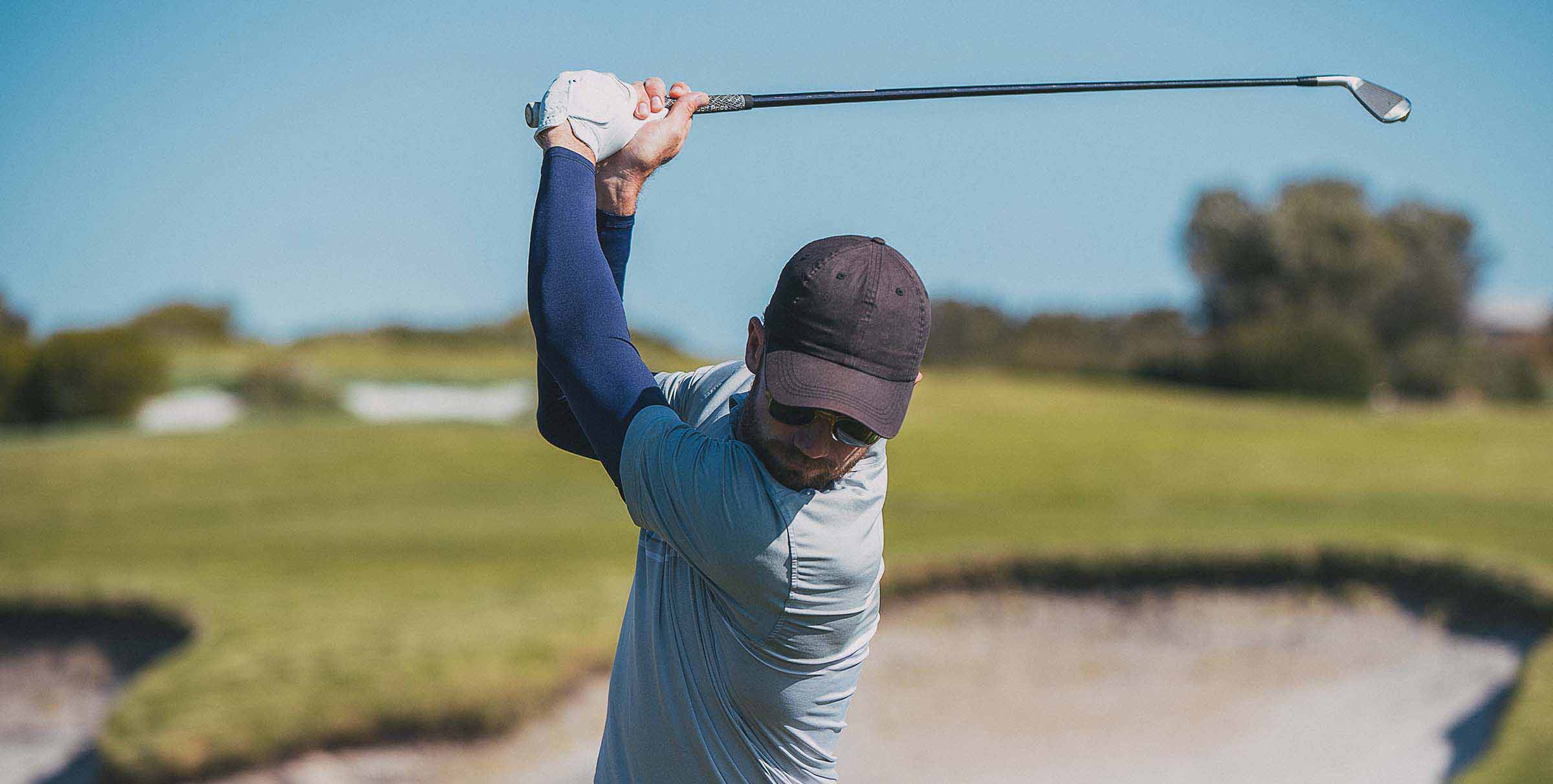 Man wearing Navy Blue Crazy Arms playing golf