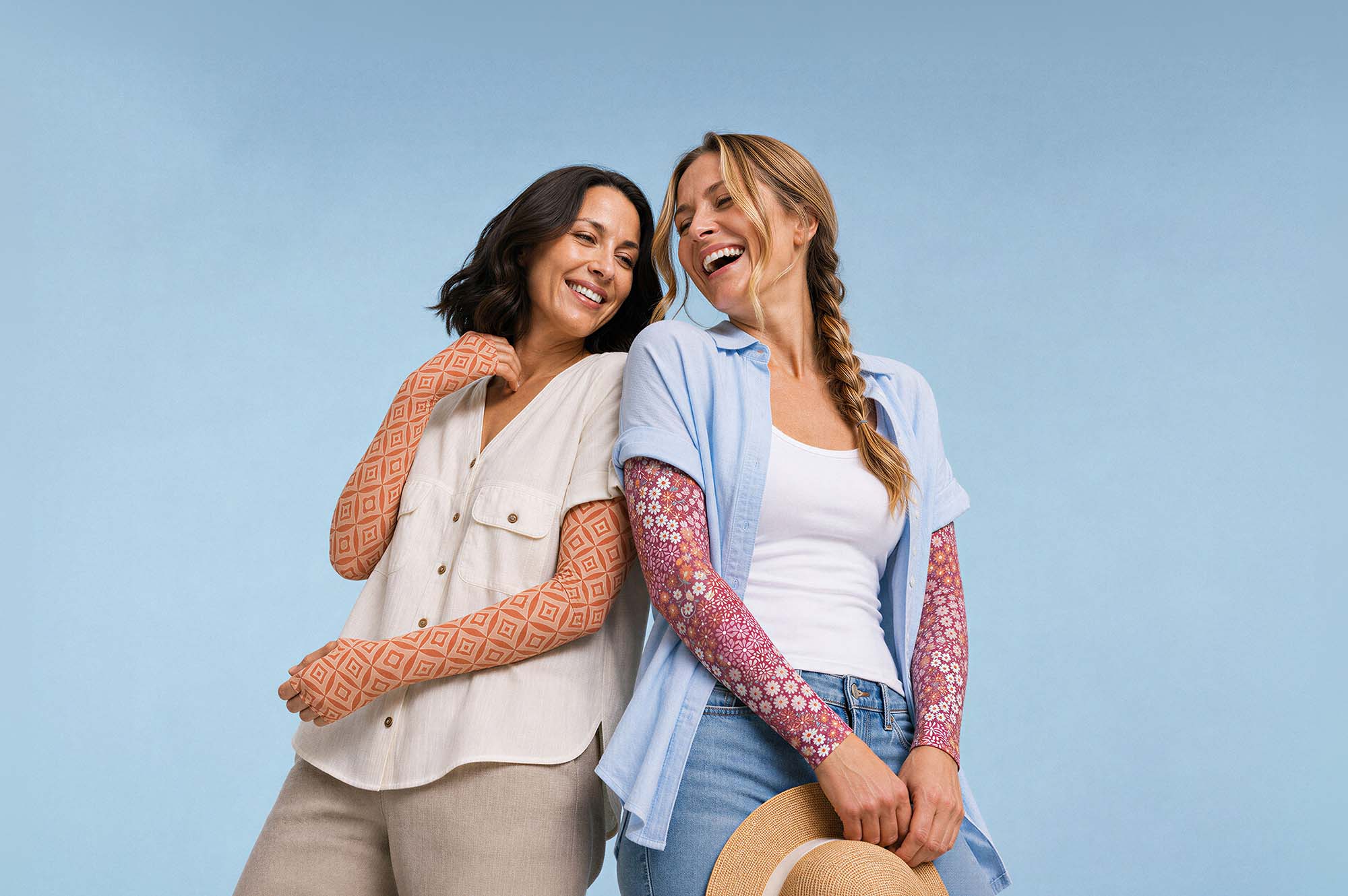 Two female friends engaging in friendly conversation on street wearing Crazy Arms sun protective sunsleeves