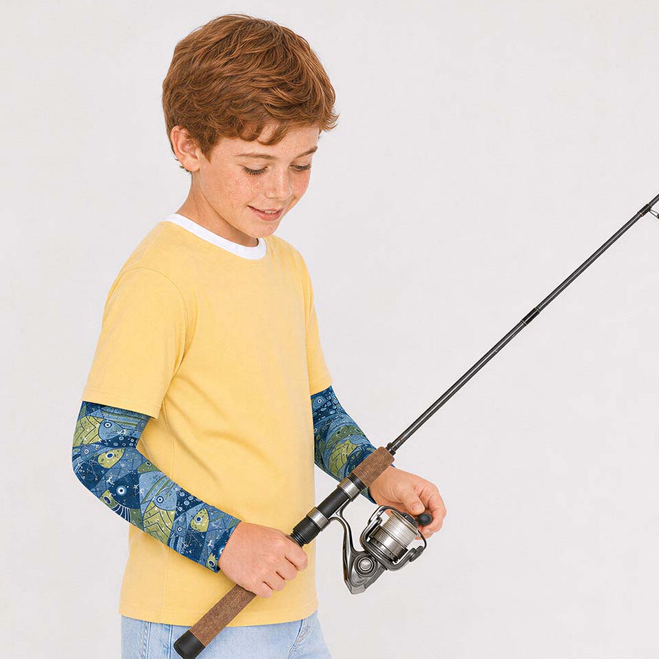 A young boy wearing a yellow short-sleeve t-shirt with blue fish-patterned sun sleeves,holding a fishing rod 